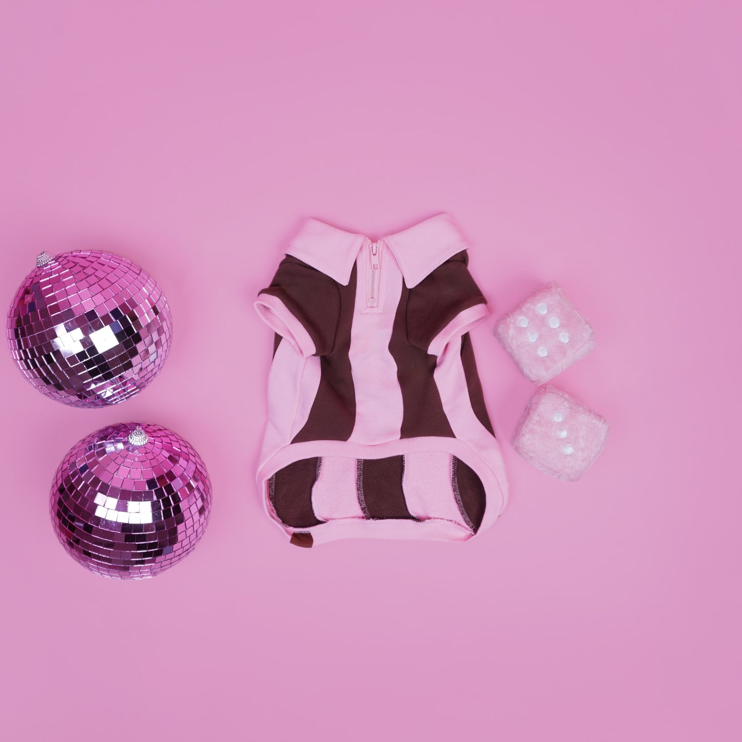 Doggy dress with pink and brown pattern, disco balls, and glittery cubes on a pink background