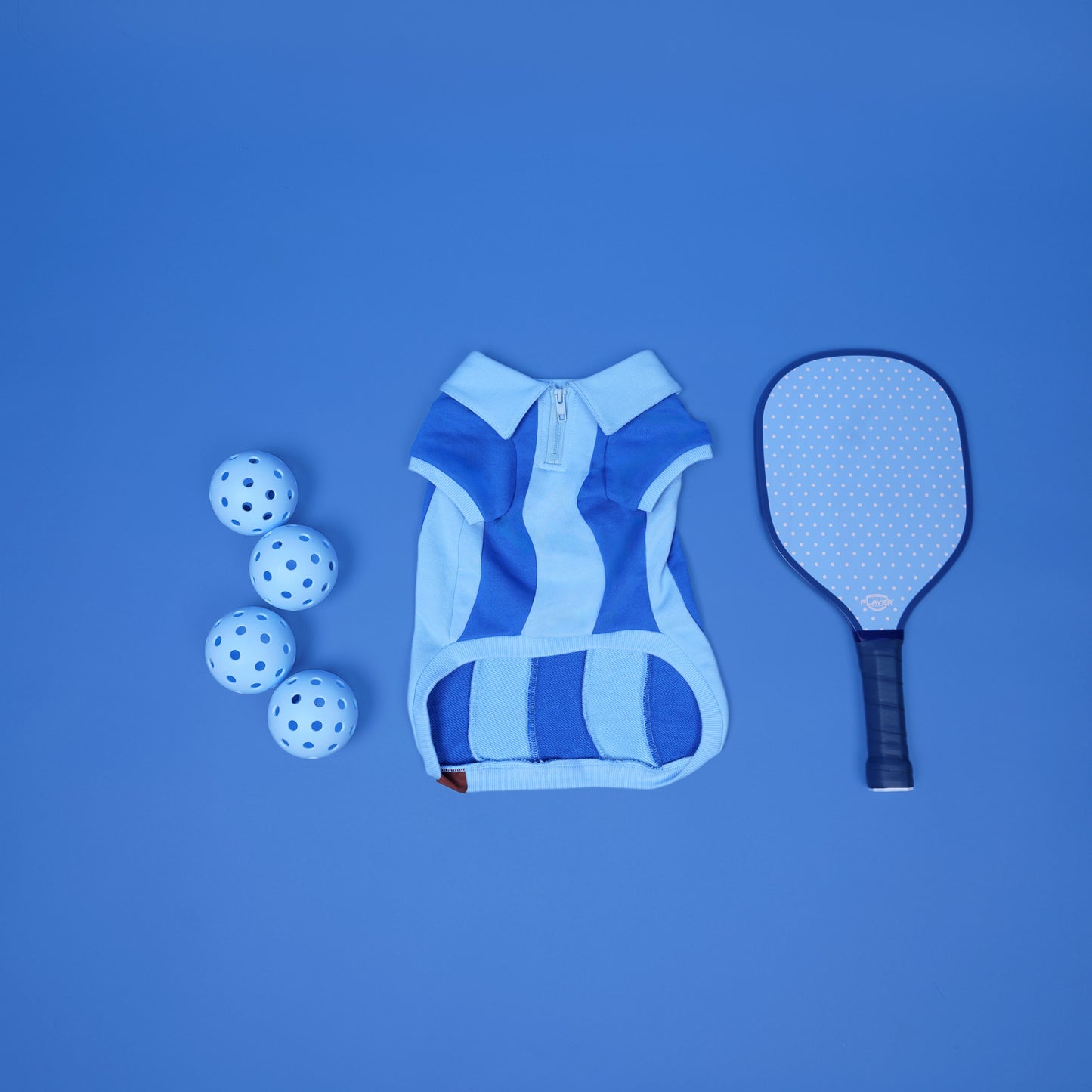 Blue sports outfit with paddle and balls on a blue background
