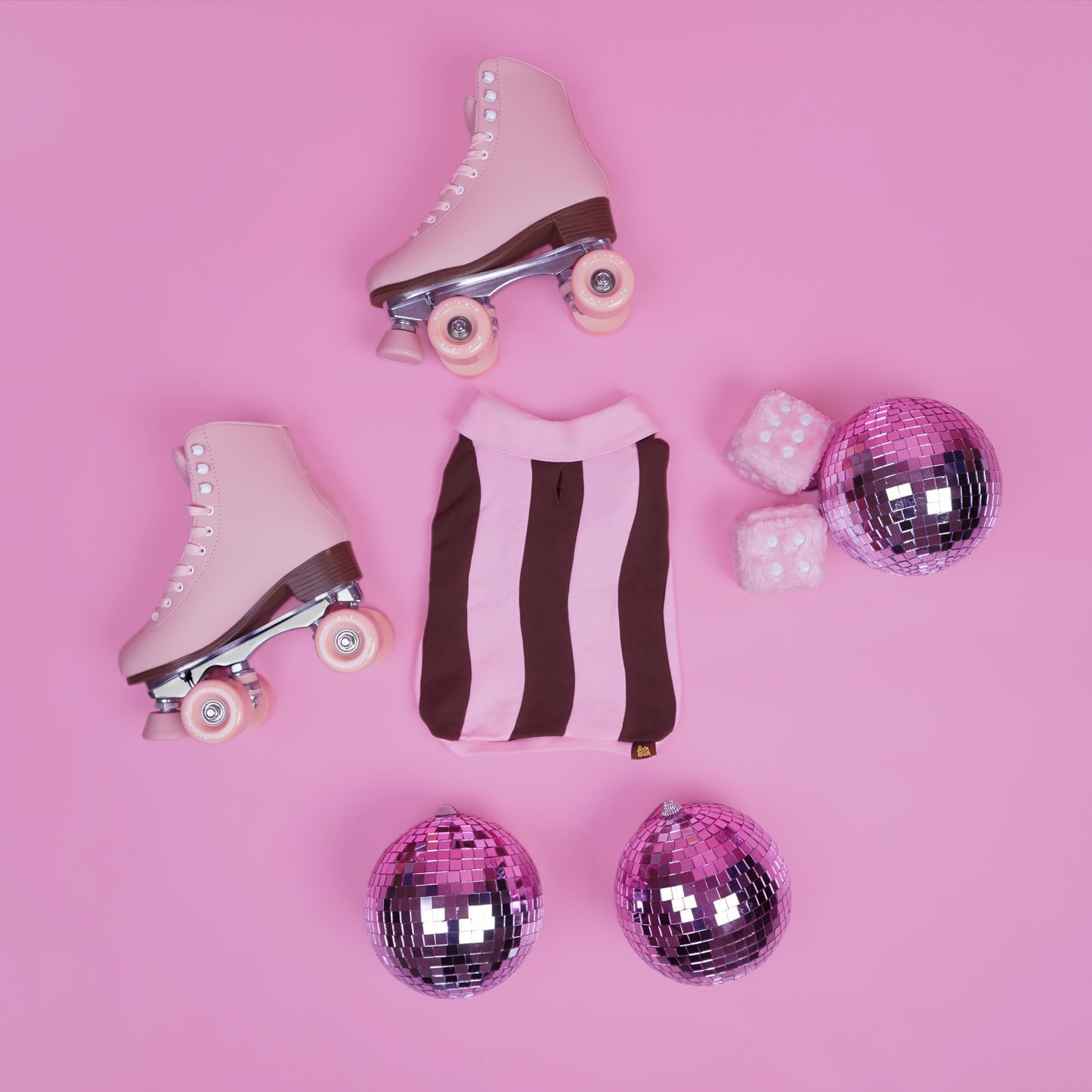 Pink roller skates with disco balls on a pink background