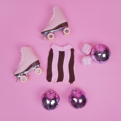 Pink roller skates with disco balls on a pink background